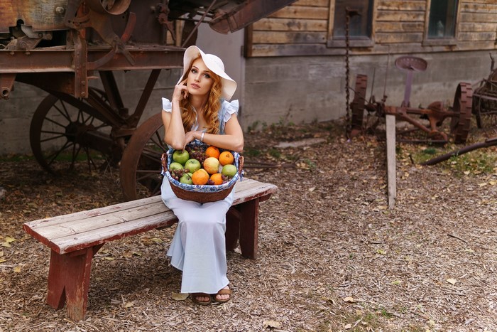 Woman in Hat with Fruit Basket on Bench