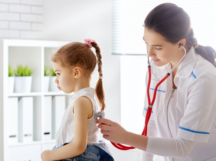 Doctor examining a young girl with a stethoscope