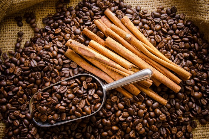 Coffee beans and cinnamon sticks on burlap