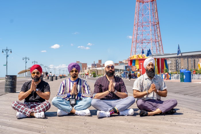 Four men meditating on a boardwalk