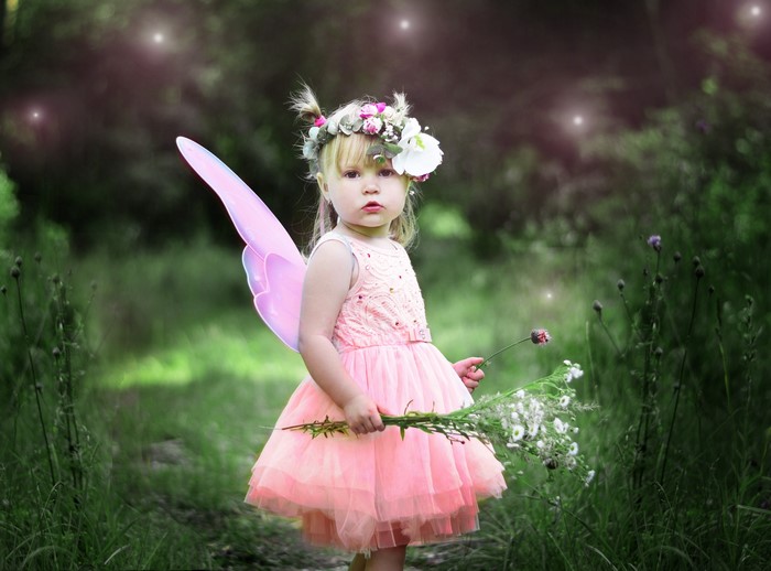 Little girl in fairy costume with flowers