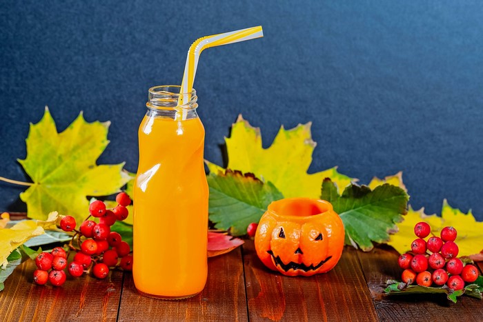 Halloween orange juice bottle with pumpkin and berries