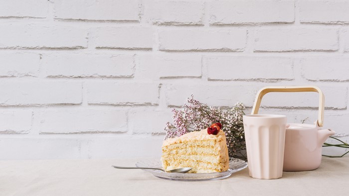 Slice of cake with tea set on table