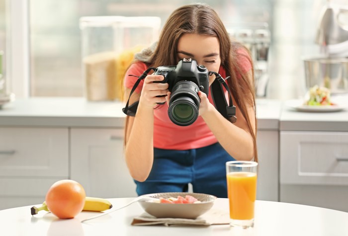 Young woman photographing food with a DSLR camera