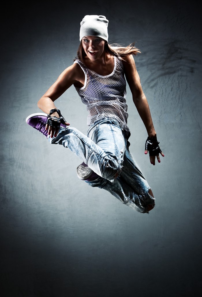 Woman in beanie and jeans jumping
