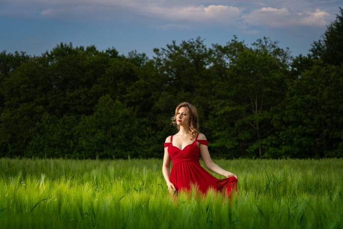 Woman in red dress in a wheat field