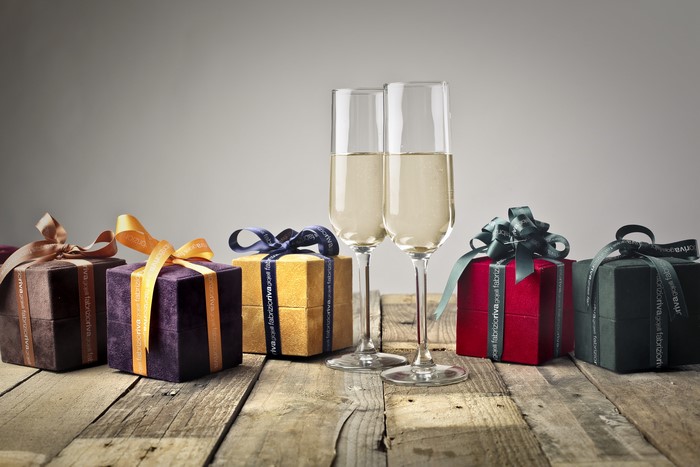 Champagne glasses and gift boxes on wood