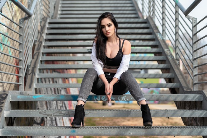 Brunette Woman Sitting on Graffiti Stairs