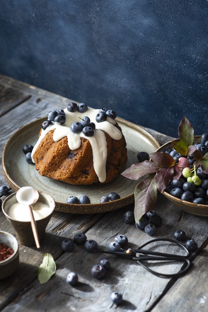 Bundt cake with blueberries and glaze on a plate