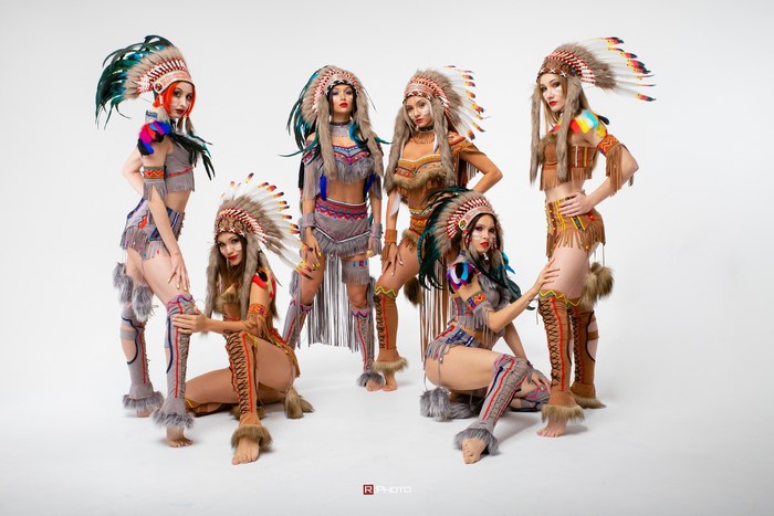 Six women in Native American costumes with headdresses