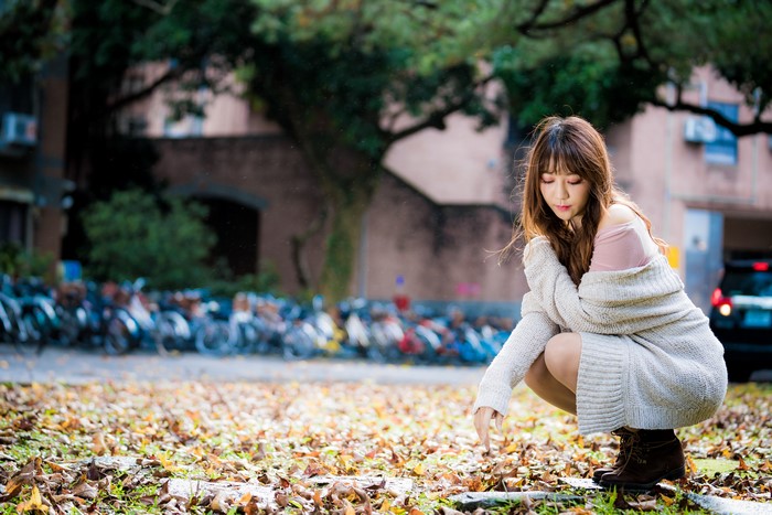4K Portrait of a Woman Sitting Amid Autumn Leaves