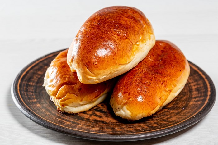 Three golden brown buns on a plate