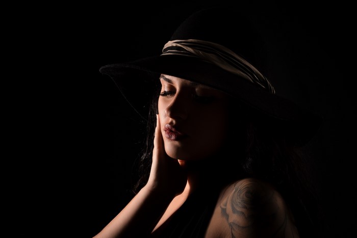 Brunette girl with tattoos wearing a hat