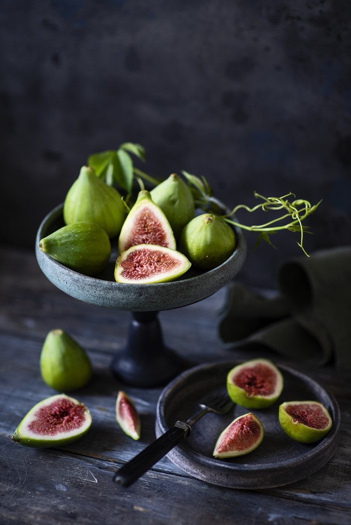 Green figs on a cake stand and plate