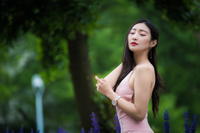 Asian woman in pink dress posing outdoors