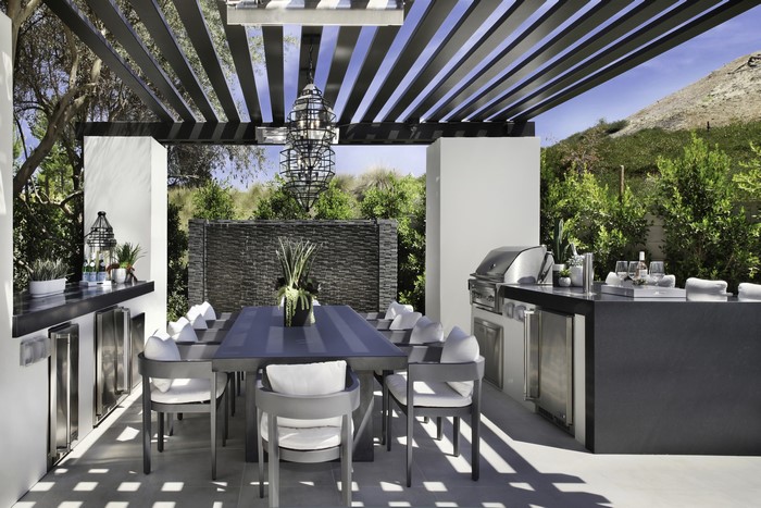 Outdoor kitchen with dining table and grill