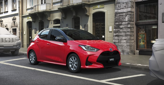 Red Toyota Yaris Hybrid parked on a street