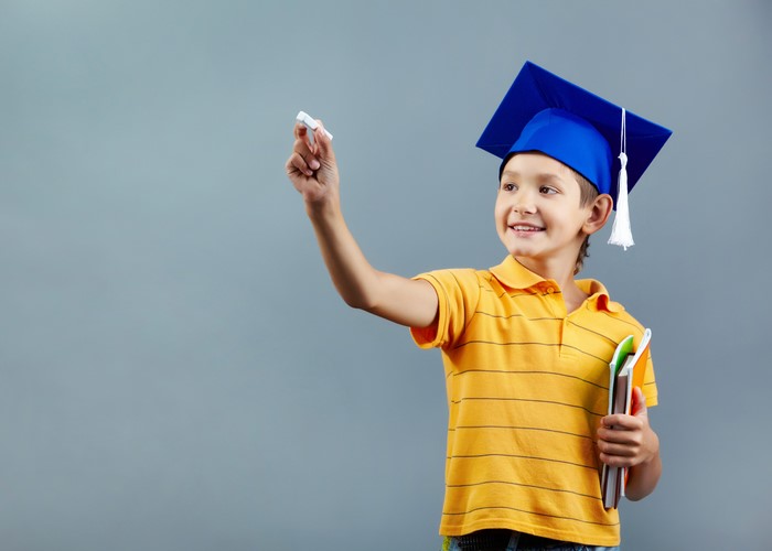 Boy in Graduation Cap Writing with Chalk