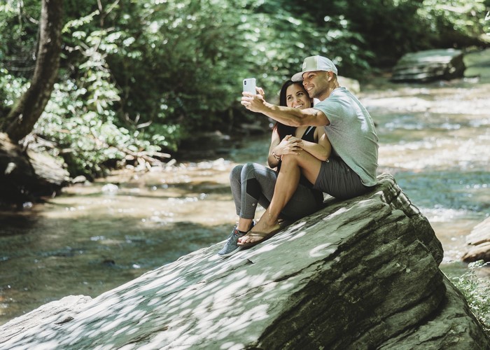 Couple taking a selfie by a stream