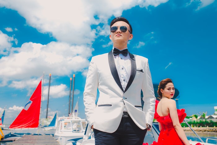 Asian man in suit and woman in red dress on a boat