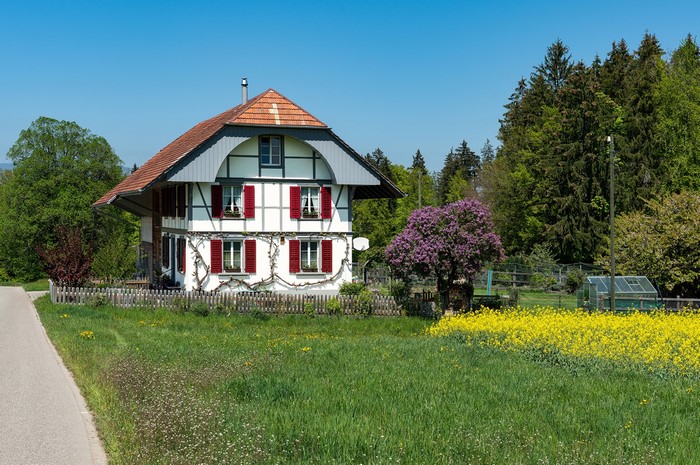 Half-timbered house in Switzerland with a field of flowers