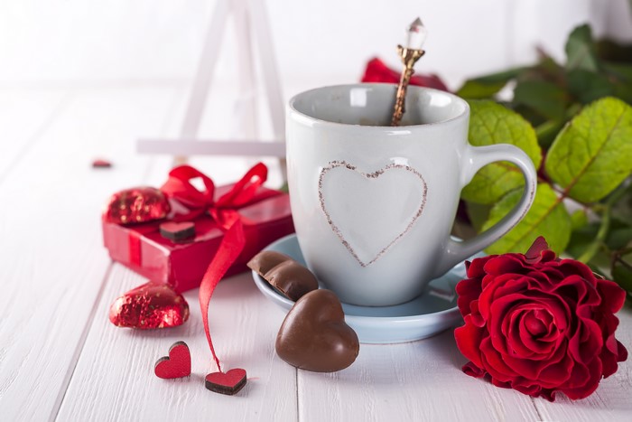 Valentine's Day coffee cup with roses and chocolates