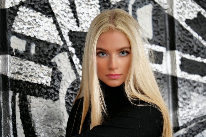 Blonde woman with blue eyes in black turtleneck