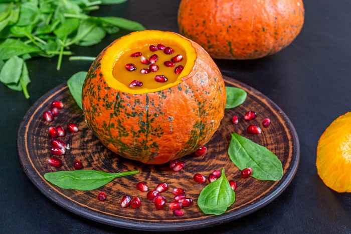 Pumpkin soup with pomegranate seeds and spinach