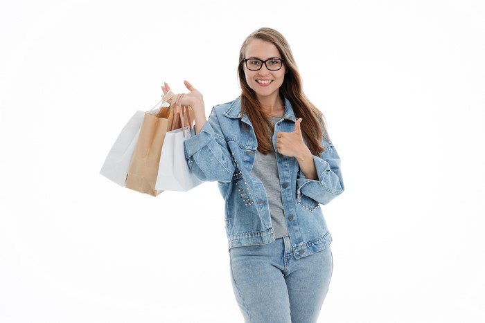 Woman with shopping bags giving thumbs up