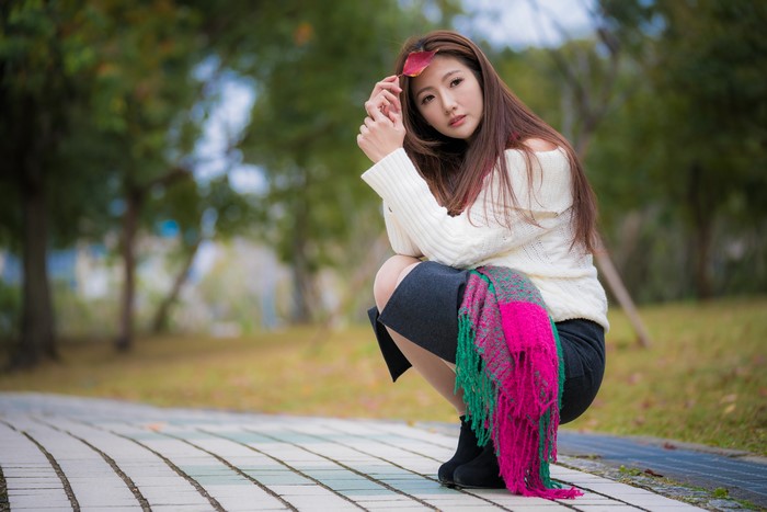 Asian woman with brown hair in a white sweater