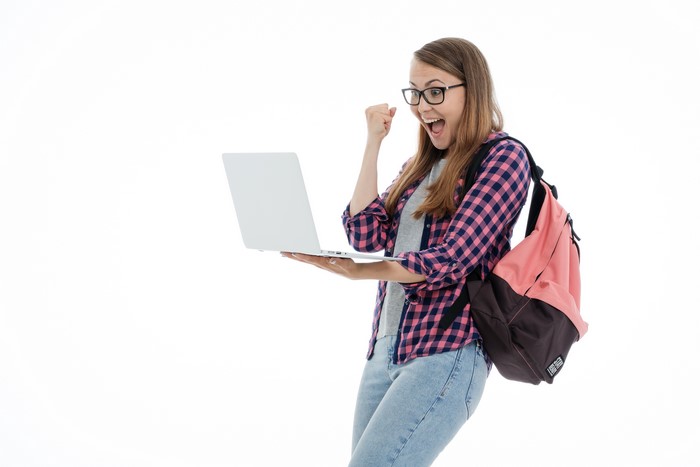 Young woman with glasses and backpack holding a laptop