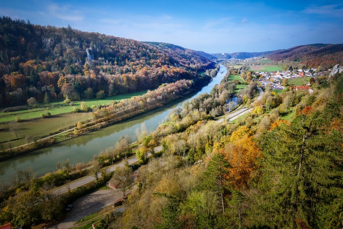 River valley with autumn forest and village in Bavaria, Germany