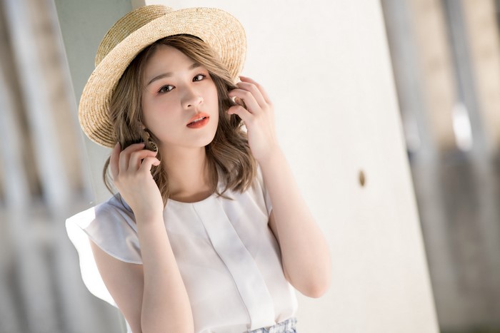 Asian woman wearing a straw hat and white top