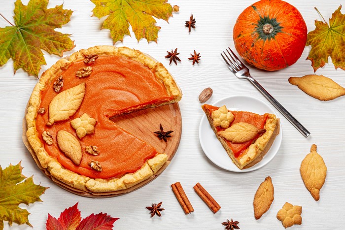 Pumpkin pie with autumn leaves and cookies