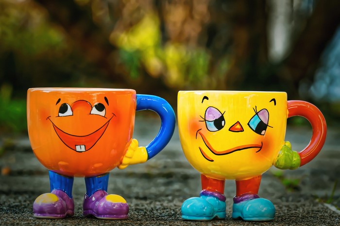 Two funny mugs with faces and legs