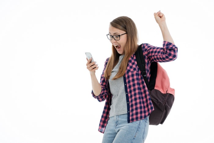 Young woman with glasses and backpack looking at phone