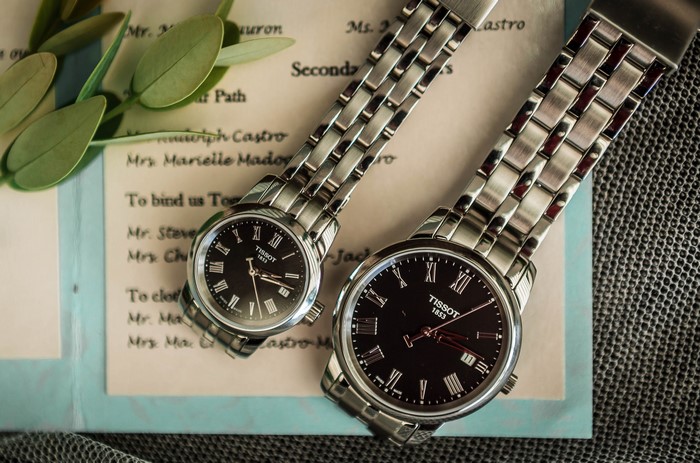 Two Tissot 1853 watches on a wedding invitation