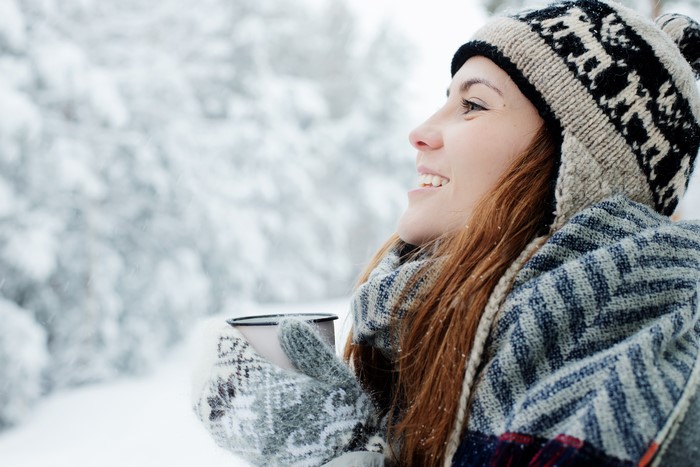 Woman in Winter Hat Holding Mug in Snow