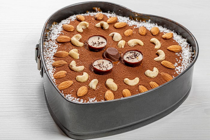 Heart-shaped chocolate cake with nuts and candies