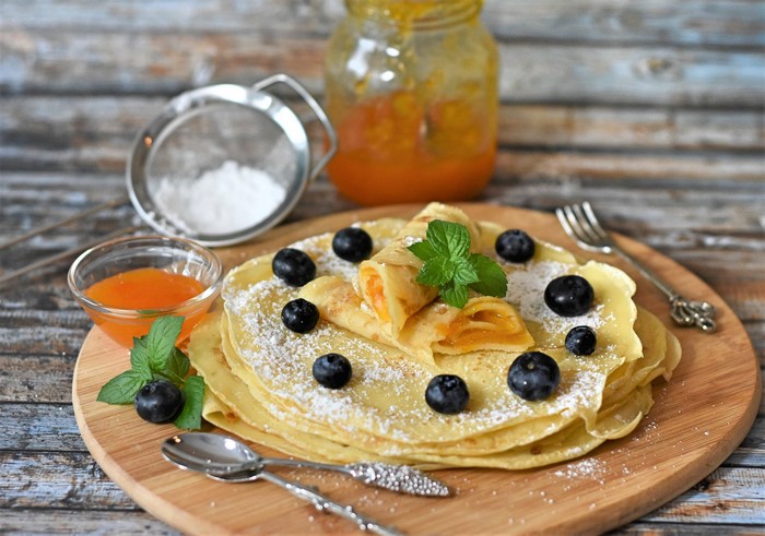 Pancakes with jam, blueberries, and powdered sugar