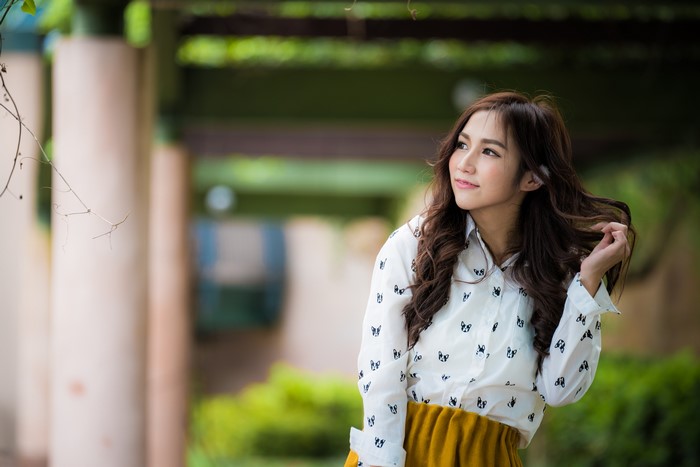 Asian woman with brown hair in a white shirt
