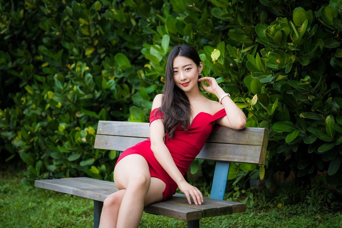 Brunette Woman in Red Dress Sitting on Bench