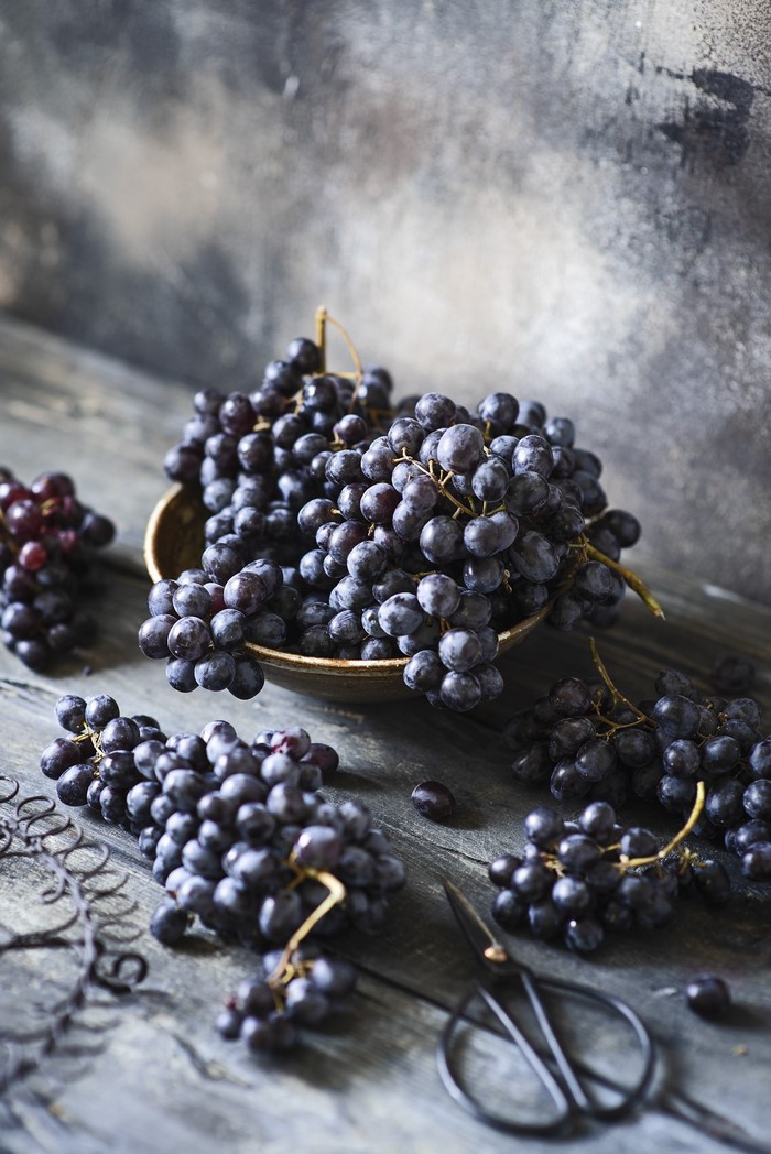 Dark Grapes on Wooden Table with Scissors