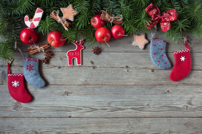 Christmas decorations with apples and pine branches on wood