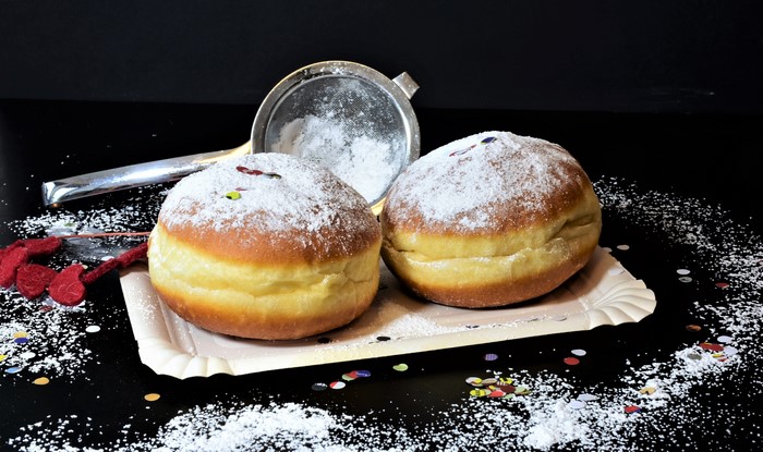 Two donuts with powdered sugar and confetti