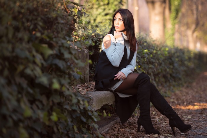 Woman Sitting Outdoors in Boots with Bokeh Effect 4K