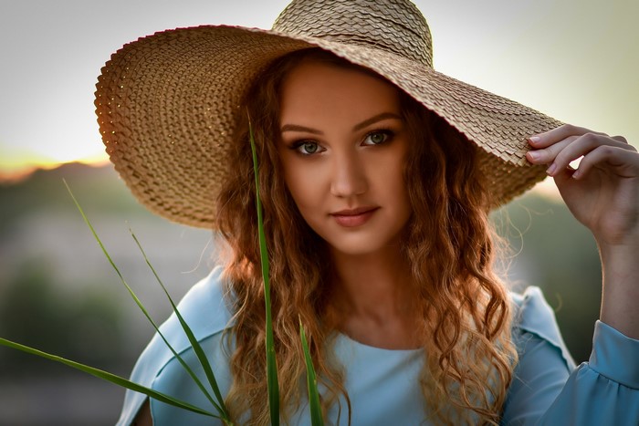Woman in a straw hat with curly hair