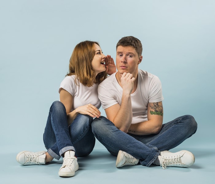 Couple sitting and whispering secrets