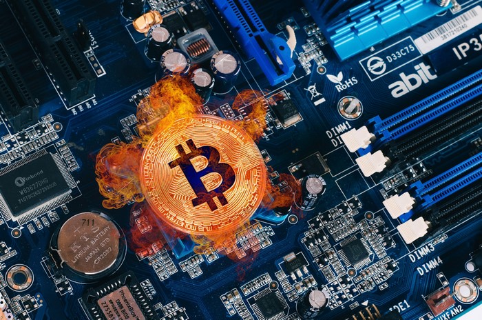 Bitcoin coin on a computer motherboard with fire