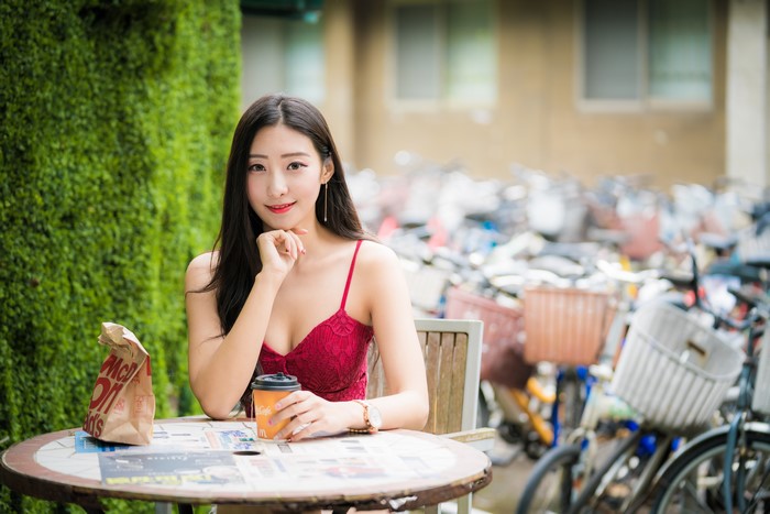 4K Image of Woman Sitting with Coffee at Outdoor Table